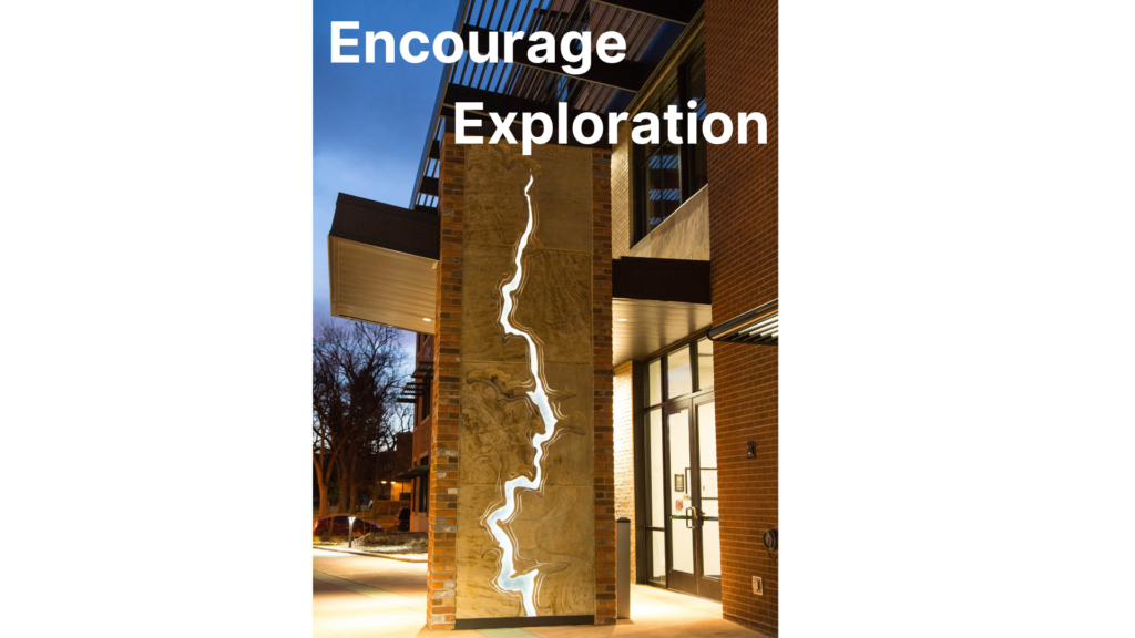 sculpture near a building with a water like split in the middle with text that reads: Encourage Exploration