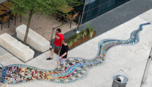 Aerial view of two people walking on a sidewalk with a colorful mosaic path