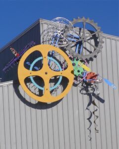 Colorful abstract metal sculpture with gears and industrial elements.
